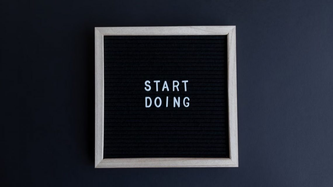 Black letter board with the motivational phrase 'Start Doing' in white text on a gray background.