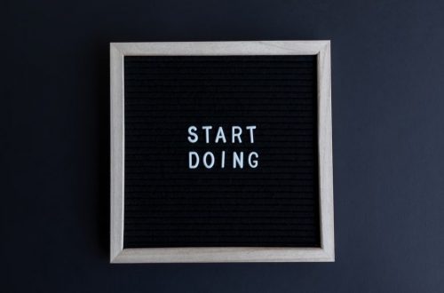 Black letter board with the motivational phrase 'Start Doing' in white text on a gray background.
