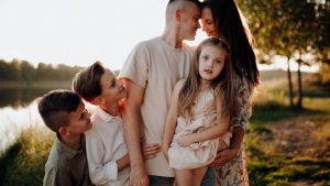 Family enjoying quality time together outdoors by the lake during sunset.