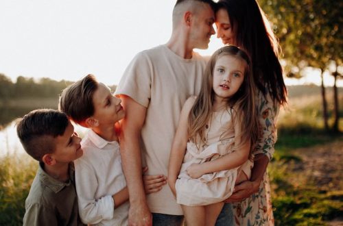 Family enjoying quality time together outdoors by the lake during sunset.
